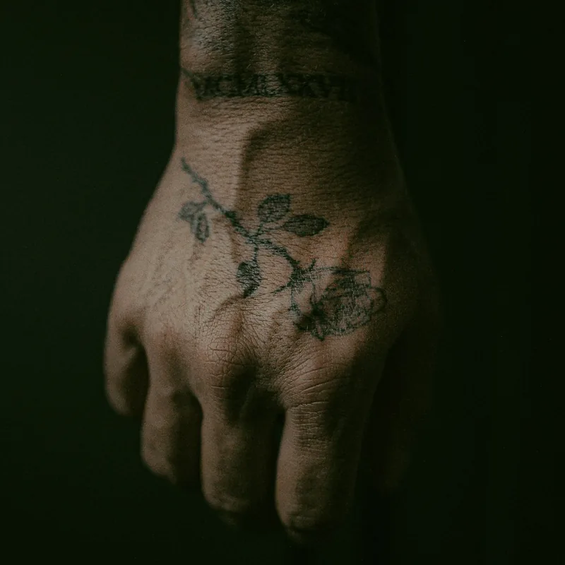 Tatouage éphémère rose sur la main, symbole d'amour et de passion Tatouage éphémère d'une rose sur le dos de la main, motif floral au trait fin