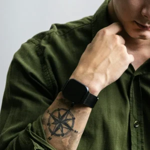 Tatouage éphémère homme discret en forme de boussole sur l'avant-bras, sous une manche de chemise remontée